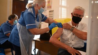 A health worker injects a dose of the AstraZeneca-Oxford Covid-19 vaccine at a temporary vaccine centre set up at City Hall in Hull, northeast England on May 7, 2021.