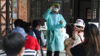 A health worker demonstrates the process of testing at a temporary Covid-19 rapid testing center in the Wanhua area of Taipei, Taiwan, on Saturday, May 15, 2021.