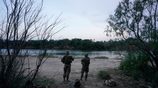 Members of the Texas Military Department stand guard along the U.S.-Mexico border Tuesday, May 11, 2021, in Roma, Texas. (AP Photo/Gregory Bull)