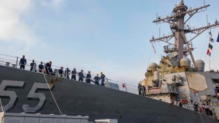 In this photo provided by the U.S. Navy, sailors aboard the guided missile destroyer USS Stout handle mooring lines during the ship's return to home port at Naval Station Norfolk, in Norfolk, Va., in this Oct. 12, 2020, photo. The USS Stout showed rust as it returned from the 210-day deployment. The rust was quickly removed and the ship repainted. But the rusty ship and its weary crew underscored the costly toll of deferred maintenance on ships and long deployments on sailors.