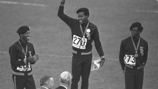 FILE - United States runners Larry James, left, Lee Evans, center, and Ron Freeman are shown after receiving their medals for the 400-meter race at the Mexico City Games in Mexico City, in this Oct. 18, 1968, file photo. Evans won gold, James took silver and Freeman got the bronze medal. Lee Evans, the record-setting sprinter who wore a black beret in a sign of protest at the 1968 Olympics, died Wednesday, May 19, 2021. He was 74. USA Track and Field confirmed Evans' death. The San Jose Mercury News reported that Evans' family had started a fundraiser with hopes of bringing him back to the U.S. from Nigeria, where he coached track, to receive medical care after he suffered a stroke last week.