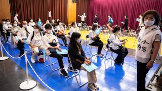 Participants take part in a Covid-19 coronavirus vaccination simulation by Japan's Self-Defence Forces at an inoculation centre in Tokyo on May 21, 2021.