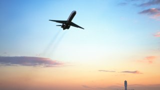 Aeroplane taking off from airport, low angle view, dusk