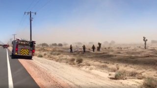 Firefighters attack a small brush fire in Lancaster in high winds on Thursday, May 20, 2021.