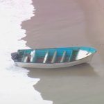 An empty boat, likely related to the human smuggling attempt, washes ashore on Thursday, May 20, 2021.