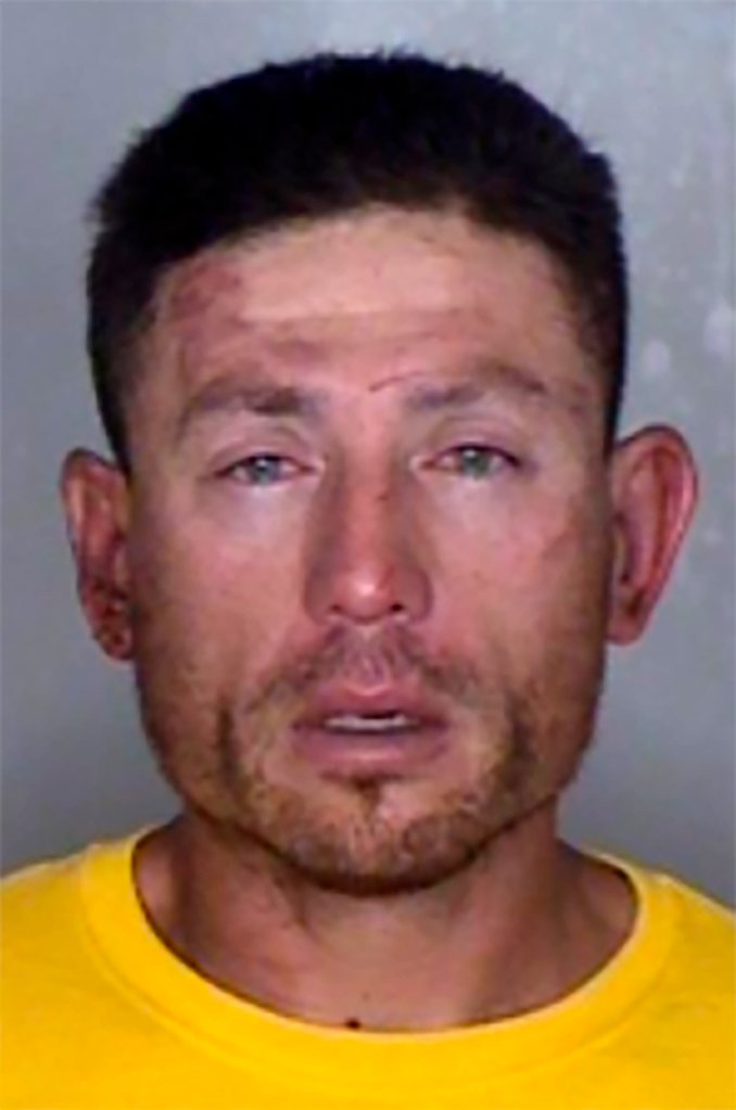A mug shot of Ryan Scott Blinston. A white man in a yellow shirt stares at the camera in this mug shot. He has light injuries on his forehead, right cheekbone and above his right eye.