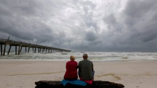 A local couple, who asked not to be named, watch waves come ashore in advance of Hurricane Michael in Pensacola, Florida, U.S. October 9, 2018. 