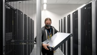 System administrator Alexander Landmann carries a server in the computer centre of Deutsche Bahn in Berlin on Oct. 22, 2020.