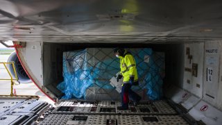 A worker checks cargo in the hold of a Boeing Co 777-300ER passenger plane, operated by Air France-KLM, before departure to Los Angeles, U.S., at Charles de Gaulle airport in Roissy, France, on Monday, May 10, 2021.