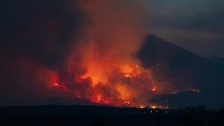 In this photo provided by Joseph Pacheco, a wildfire is seen burning in Globe, Ariz., on Monday, June 7, 2021. Firefighters in Arizona were fighting Tuesday to gain a foothold into a massive wildfire, one of two that has forced thousands of evacuations in rural towns and closed almost every major highway out of the area.