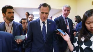 Sen. Mitt Romney, R-Utah, is surrounded by reporters as he walks to the Senate chamber for votes, at the Capitol in Washington, Thursday, June 10, 2021. Sen. Romney is working with a bipartisan group of 10 senators negotiating an infrastructure deal with President Joe Biden.