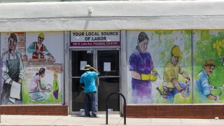 In this May 7, 2020, file photo, a person looks inside the closed doors of the Pasadena Community Job Center during the coronavirus outbreak in Pasadena, Calif. California will stop giving unemployment benefits to people who are not actively applying for jobs, Gov. Gavin Newsom's administration announced Thursday, June 17, 2021.