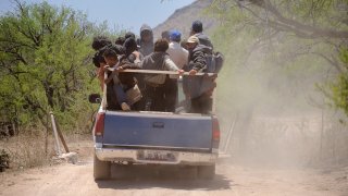 A group of Mexican migrants being transported by Coyotes (people smugglers) to a drop off point in the desert before beginning the treacherous trek through the desert to cross the border into the USA, near the town of Sasabe. Sasabe is the departure point for as many as 1000 migrants a day, most from Mexico, who cross the border illegally into the USA by going around, over, and through the fence between the two countries.