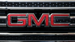 A closeup of the GMC logo on a car's grill.