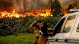U.S. Forest Service firefighters Chris Voelker, left, and Kyle Jacobson monitor the Sugar Fire