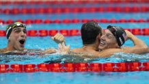 Caeleb Dressel, of United States, celebrates after winning the gold medal in a men's 50-meter freestyle fiat the 2020 Summer Olympics, Sunday, Aug. 1, 2021, in Tokyo, Japan. At left Bruno Fratus, of Brazil, celebrates winning the bronze medal.