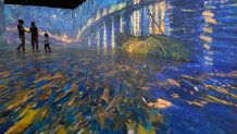 Visitors walk through "Starry Night Over the Rhone," at "Beyond Van Gogh" exhibit on April 12, 2021 in Miami. (Gayaman Visual Studio)