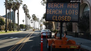 A road sign announces closures at Santa Monica beach amid the coronavirus pandemic on March 27, 2020 in Santa Monica, California. (Photo by Mario Tama/Getty Images)