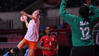 Netherlands' left wing Bo van Wetering (L) jumps to shoot during the women's preliminary round group A handball match between The Netherlands and Angola