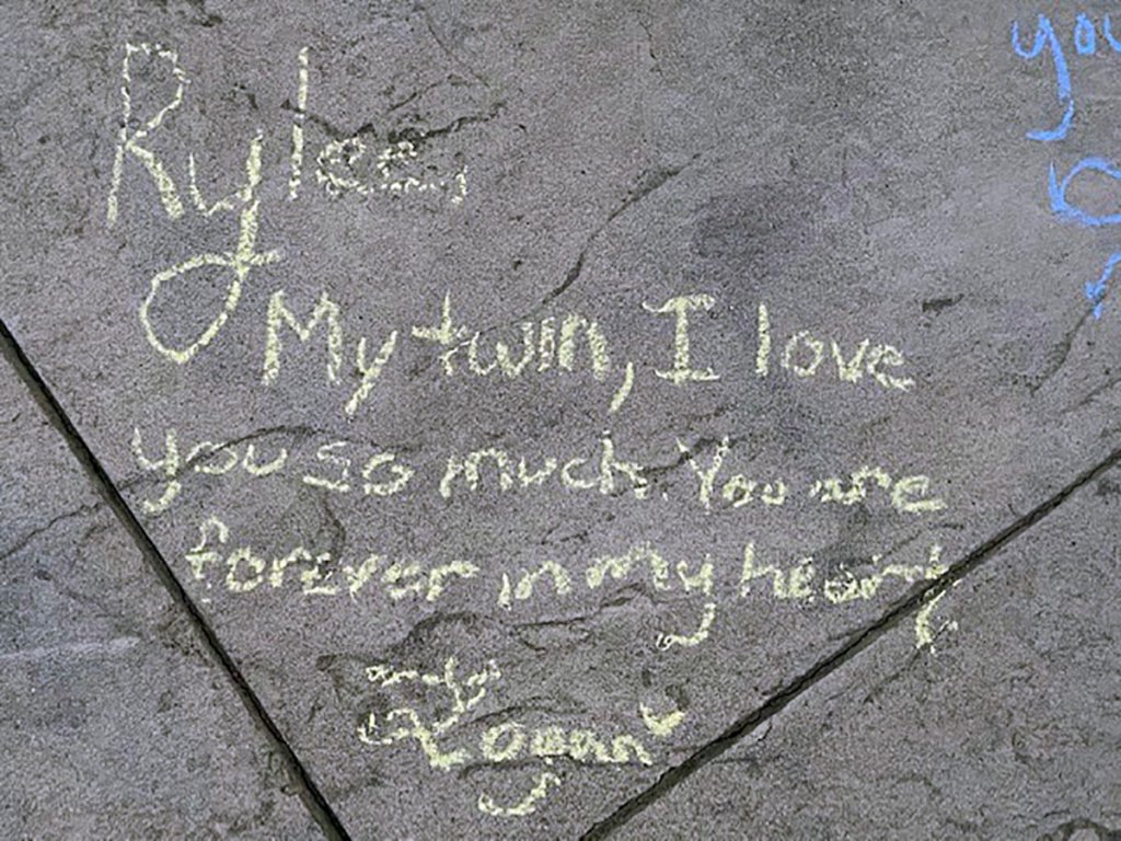 Messages in honor of Rylee Goodrich, 19, and Anthony Barajas, 18, were left outside a movie theater at The Crossings mall in Corona.