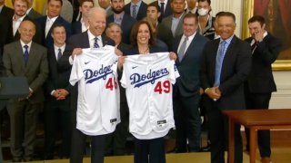 President Biden and Vice President Harris hold jerseys presented to them by the Dodgers.