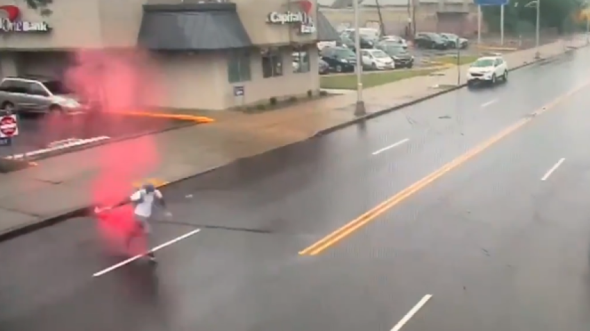 A red dye pack explodes on an accused bank robbery moments after fleeing the Newark property.