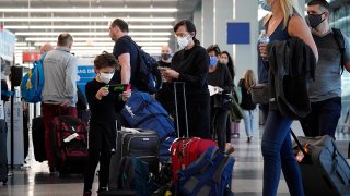 FILE - Travelers line up at O'Hare airport in Chicago, July 2, 2021.