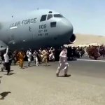 Hundreds of people run alongside a U.S. Air Force C-17 cargo plane trying to take off at Kabul International Airport, Kabul, Afghanistan, Aug. 16, 2021.