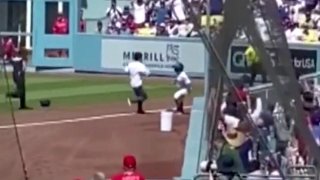 A fan’s romp in the Dodger Stadium outfield was upended by a Dodgers ball girl Aug. 8, 2021.