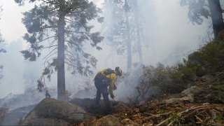 Will Fitch, fire captain from Cosumnes Fire Department, holds a fire line to keep the Caldor Fire from spreading in South Lake Tahoe, Calif., Friday, Sept. 3, 2021.