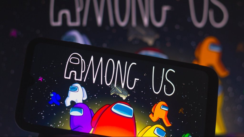 In this photo illustration, the Among Us logo is displayed on a smartphone.  Among Us is an online arcade game in the group game and survival genre.