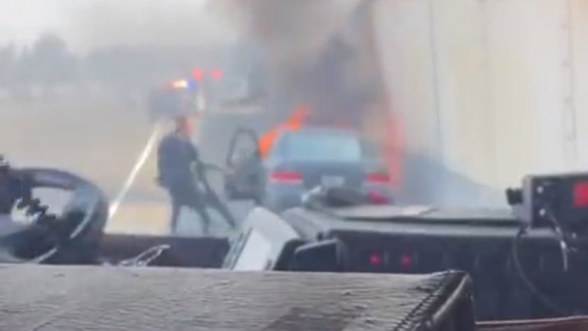 A San Jose police officer pulls a man from a burning car.