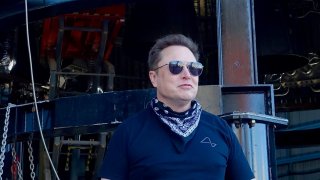 SpaceX CEO Elon Musk stands at the base of a Starship rocket prototype at the company’s facility in Boca Chica, Texas.