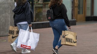 Pedestrians carry Nike shopping bags in San Francisco on Sept. 16, 2021.