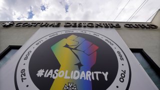 A poster advocating union solidarity hangs from a Costume Designers Guild office building