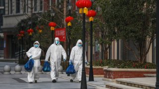 This photo taken on February 20, 2020 shows community staff members delivering foods to residents in Wuhan in China's central Hubei province.