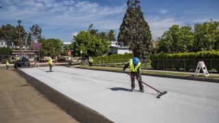 New cool slurry pavement is added to a street in Los Angeles.