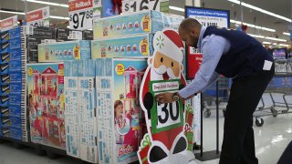 Jonathan Mary fixes the sign indicating that there are 30 more days until Christmas at a Walmart store in Miami, Florida.