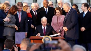 U.S. President Joe Biden celebrates with lawmakers including Vice President Kamala Harris, House Speaker Nancy Pelosi (D-CA) and Senate Majority Leader Chuck Schumer (D-NY) before signing the Infrastructure Investment and Jobs Act on the South Lawn at the White House in Washington, November 15, 2021.