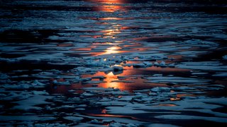FILE – The midnight sun shines across sea ice along the Northwest Passage in the Canadian Arctic Archipelago, Sunday, July 23, 2017.