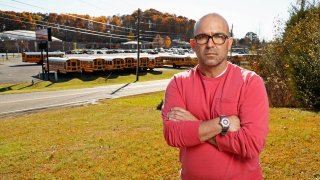 Man stands across the street from high school building