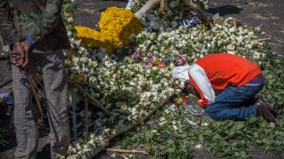 An Ethiopian relative of a crash victim mourns and grieves next to a floral tribute at the scene where the Ethiopian Airlines Boeing 737 Max 8 crashed shortly after takeoff on Sunday killing all 157 on board, near Bishoftu, south-east of Addis Ababa, in Ethiopia Friday, March 15, 2019. Analysis of the flight recorders has begun in France, the airline said Friday, while in Ethiopia officials started taking DNA samples from victims' family members to assist in identifying remains.