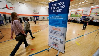 A voter is led to a check-in desk to register to cast a ballot inside at the La Familia Recreation Center in the Baker neighborhood Tuesday, Nov. 3, 2020, south of downtown Denver.