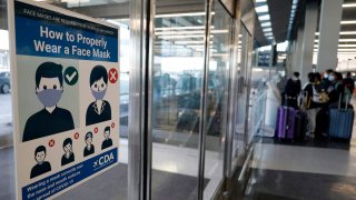 This July 2, 2021 file photo shows a sign stating face coverings are required is displayed at O'Hare airport in Chicago. The Federal Aviation Administration says it has referred 37 cases involving unruly airline passengers to the FBI for possible criminal prosecution since the number of disruptions on flights began to spike in January. FAA and Justice Department officials said Thursday, Nov. 4, 2021 that in the last three months they developed a process for the FAA to regularly send cases to the FBI, which forwards those worthy of prosecution to field offices for investigation.