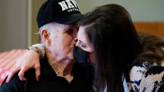 FILE - Jim Young, a Navy veteran, kisses his daughter Holly Hurst, without the use of protective garments at the Mississippi State Veterans Home in Collins, Miss., as part of Operation "Family Reunion," April 1, 2021. The government on Friday, Nov. 12, directed nursing homes to open their doors wide to visitors, easing many remaining pandemic restrictions while urging residents, families and facility staff to keep their guard up against outbreaks.