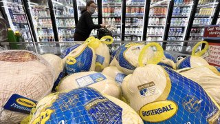 FILE - A shopper walks past turkeys for sale in a grocery store ahead of the Thanksgiving holiday on Nov. 11, 2021 in Los Angeles, California.