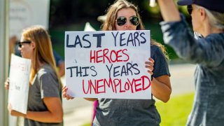 A sign held by a healthcare worker reads “Last Year’s Heroes, This Year’s Unemployed” at a protest at St. Catherine of Siena Hospital in Smithtown, New York, on Sept. 27, 2021.