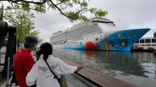 People pause to look at Norwegian Cruise Line's ship, Norwegian Breakaway, on the Hudson River, in New York