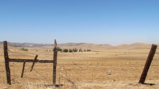 A barbed wire fence runs along a ranch in Sites, Calif., on July 23, 2021.