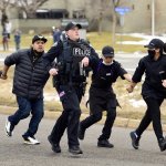 Police, King Soopers employees and customers run down Table Mesa Drive in Boulder after reports of shots fired inside on Monday, March 22, 2021. Ten people were killed by a gunman at the King Soopers supermarket.
